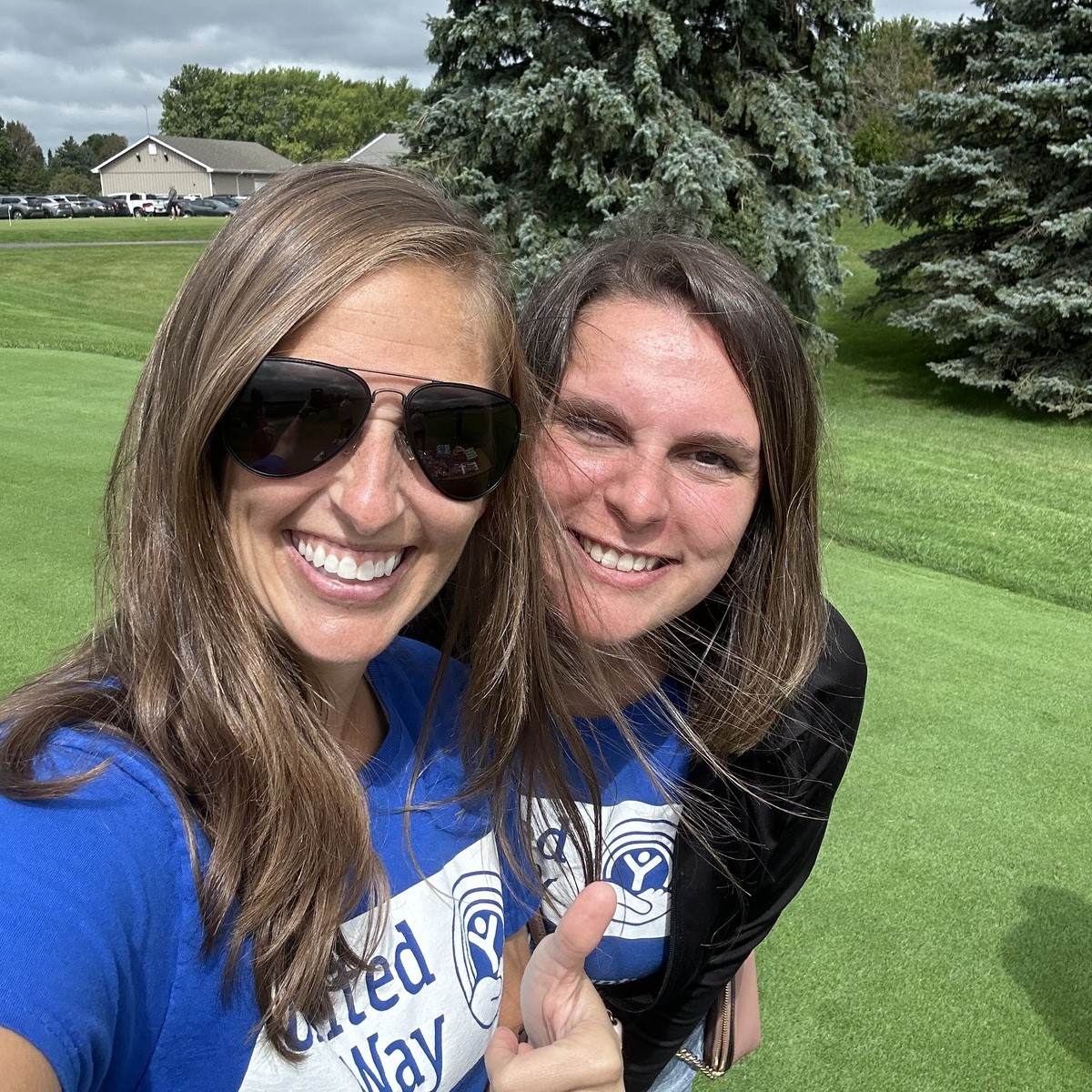 Two Emerging Leaders taking a selfie at the charity golf outing.