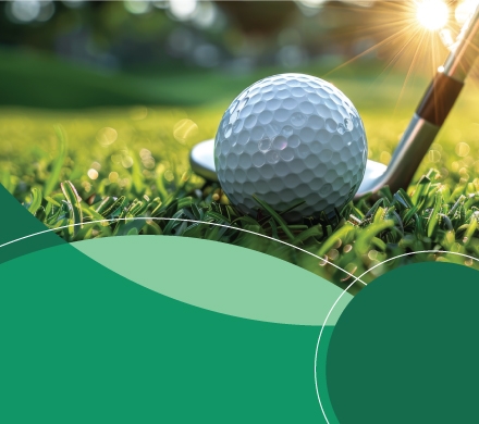 Photo of golf ball on grass with golf club next to it.