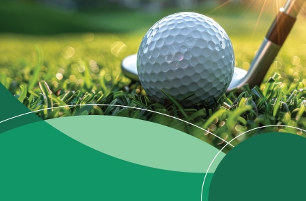 Photo of golf ball on grass with golf club next to it.